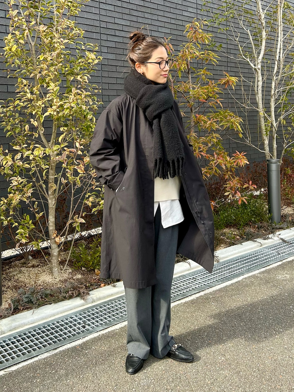 ホワイト系のニット/セーター、ホワイト系のシャツ/ブラウス、グレー系のスラックスを着用したレディースの冬コーディネートの3枚目の写真