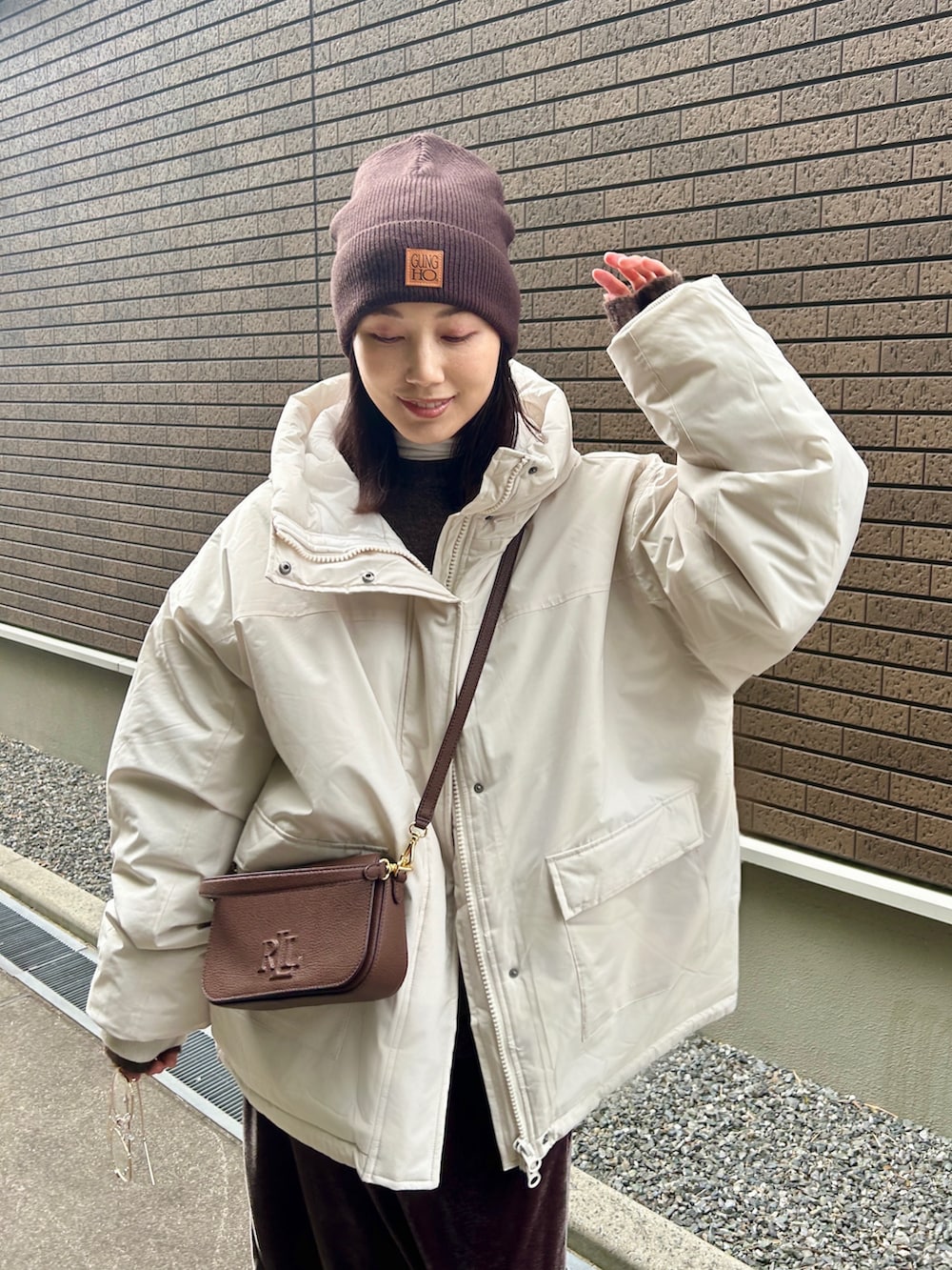 ホワイト系のブルゾン、ブラック系のブーツ、ブラウン系のニット/セーターを着用したレディースの冬コーディネートの3枚目の写真