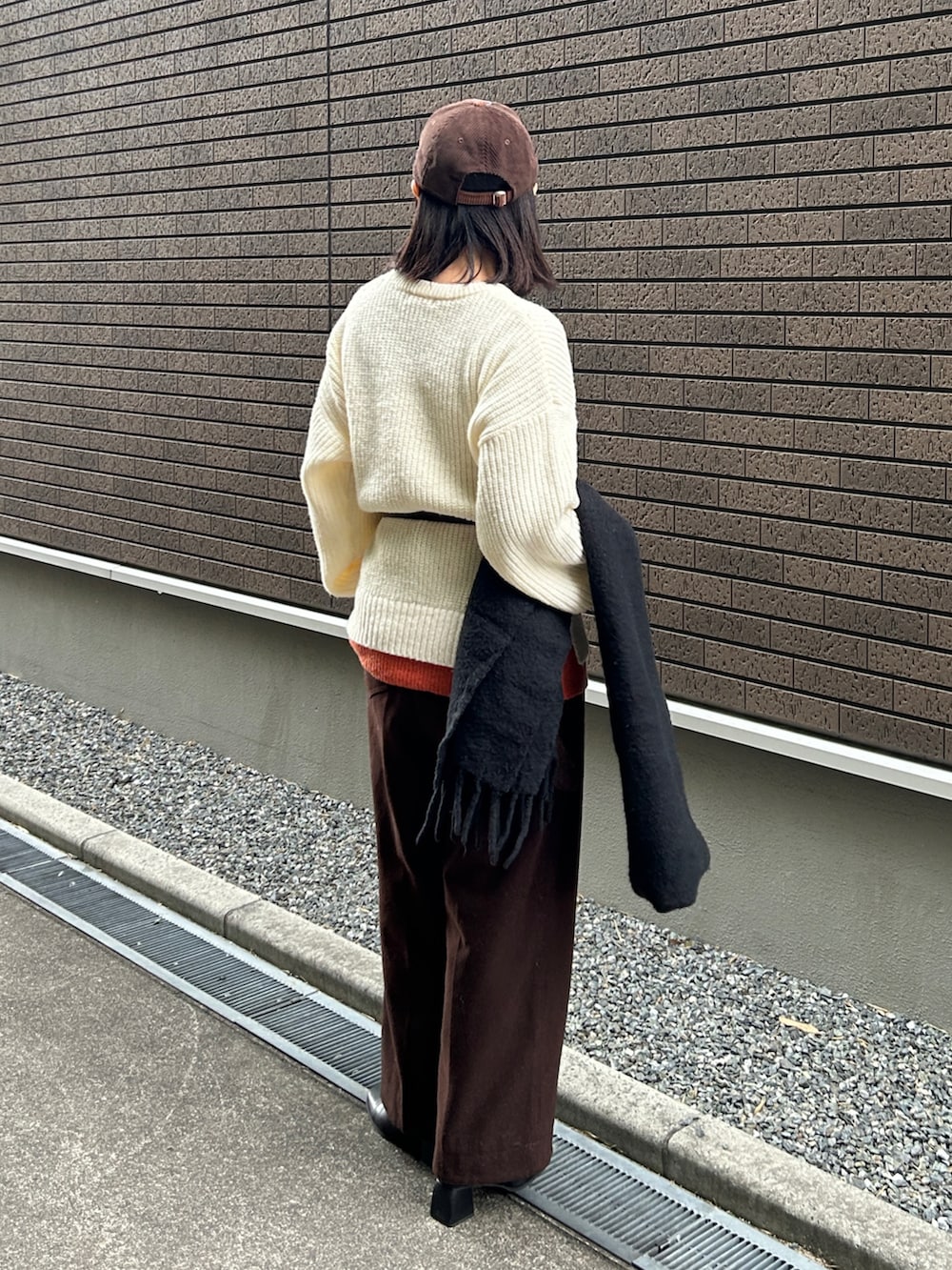 ホワイト系のニット/セーター、ブラック系のブーツ、ブラウン系のその他パンツを着用したレディースの冬コーディネートの5枚目の写真