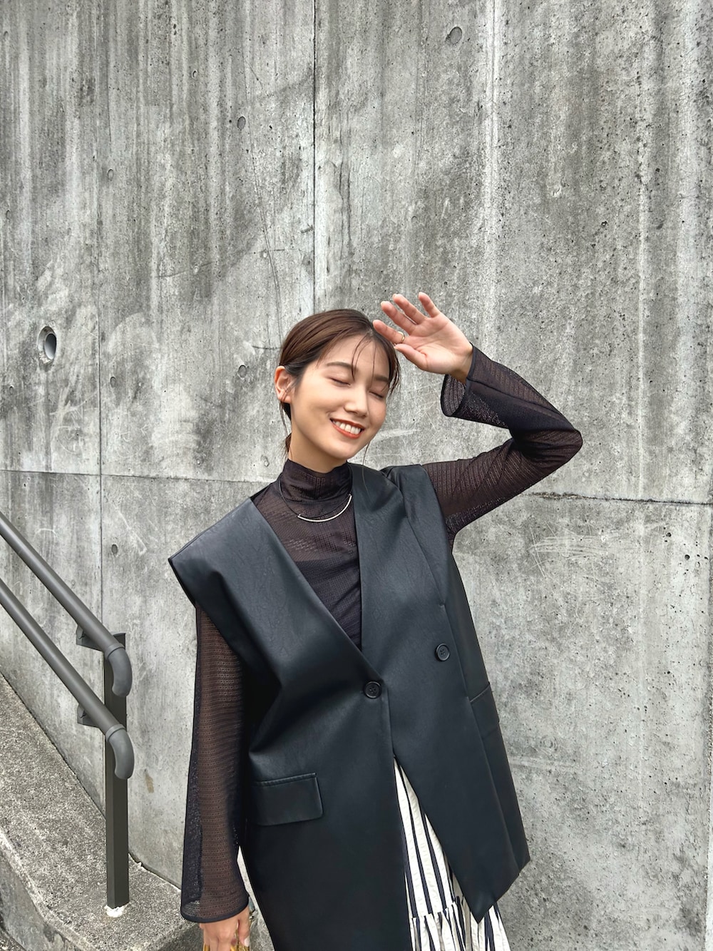 ブラック系のトップス、ブラック系のキャミソール、ブラック系のベストを着用したレディースの秋コーディネートの5枚目の写真