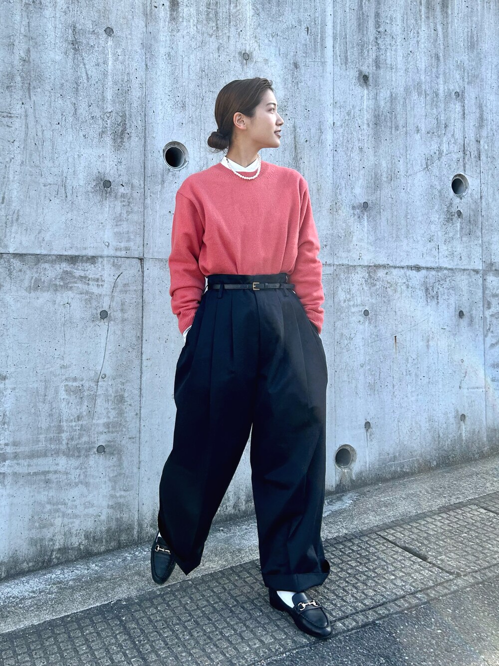 ブラック系のパンツ、ピンク系のニット/セーター、ブラック系のローファーを着用したレディースの春コーディネートの2枚目の写真