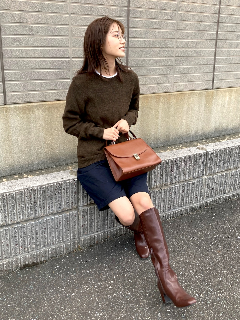 ブラウン系のブーツ、ブラック系のチノパンツ、ブラウン系のニット/セーターを着用したレディースの秋コーディネートの2枚目の写真