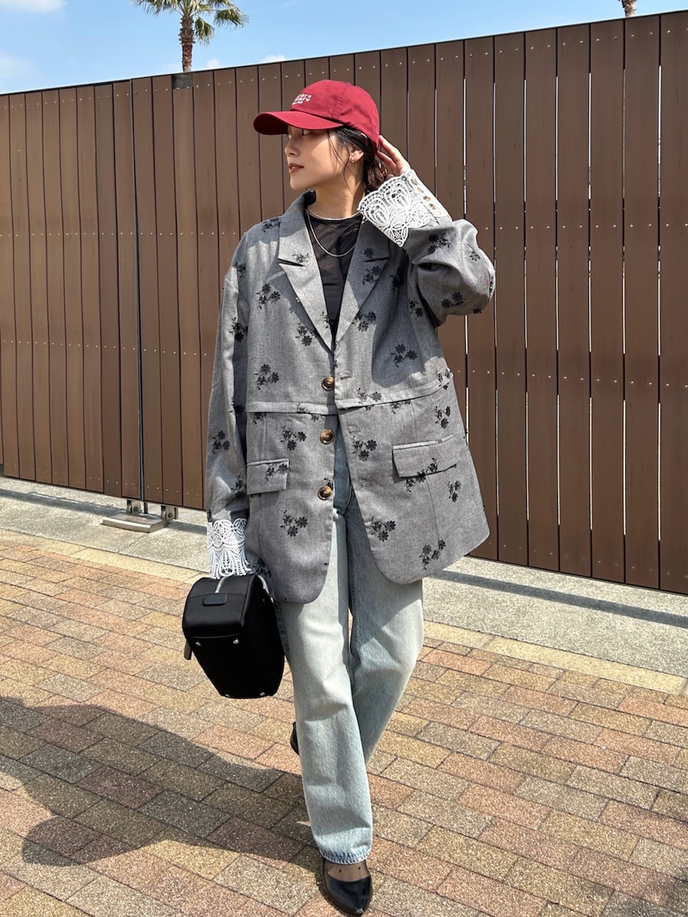 ブラック系のテーラードジャケット、ブラック系のボストンバッグ、ブラック系のパンプスを着用したレディースの春コーディネートの2枚目の写真