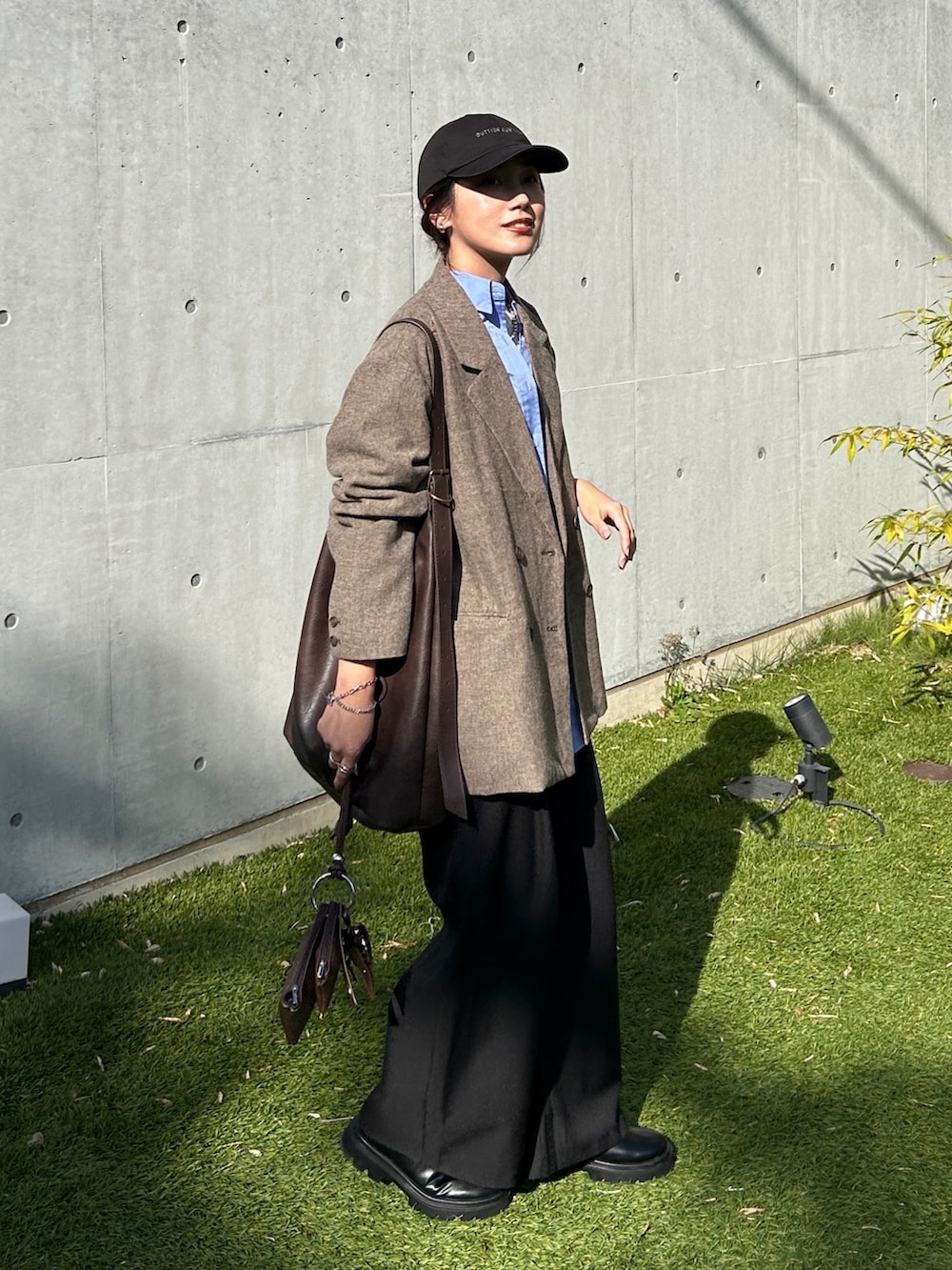 ベージュ系のテーラードジャケット、ブラック系のブーツ、ブルー系のシャツ/ブラウスを着用したレディースの秋コーディネートの4枚目の写真