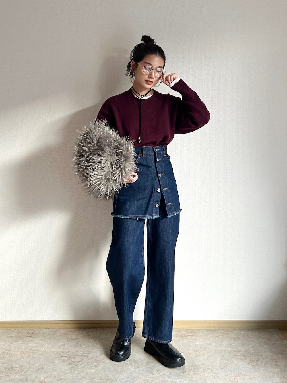 グレー系のハンドバッグ、ブルー系のデニムスカート、ブルー系のデニムパンツを着用したレディースの冬コーディネートの2枚目の写真