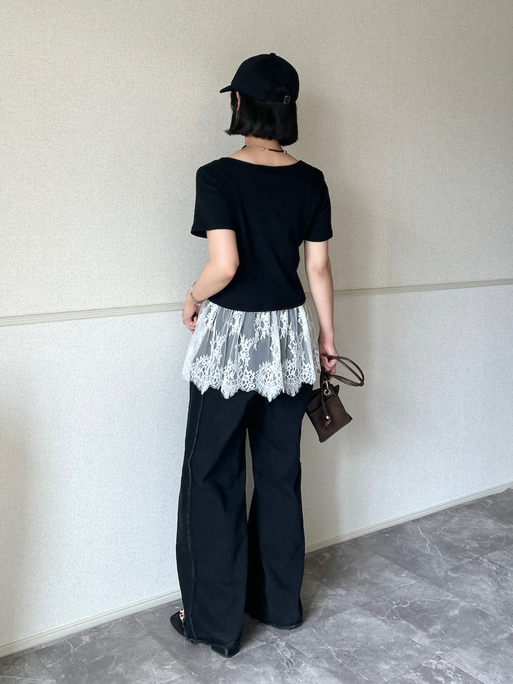 その他のデニムパンツ、ブラック系のサンダル、ブラウン系のショルダーバッグを着用したレディースの夏コーディネートの2枚目の写真