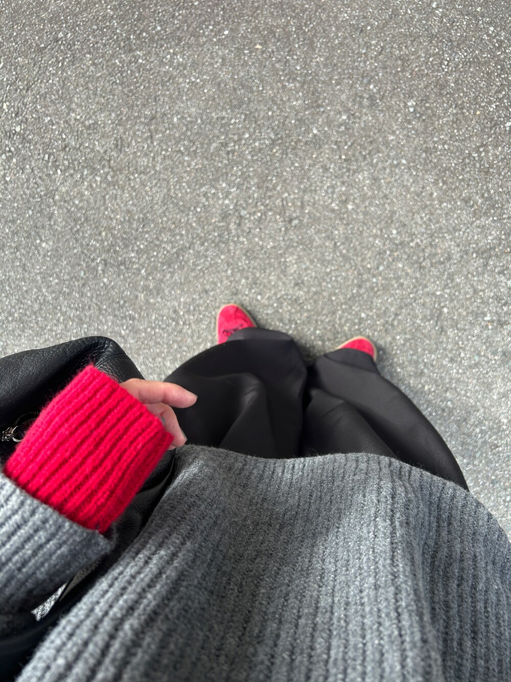 グレー系のニット/セーター、ブラック系のハンドバッグ、ブラック系のスラックスを着用したレディースの秋コーディネートの4枚目の写真