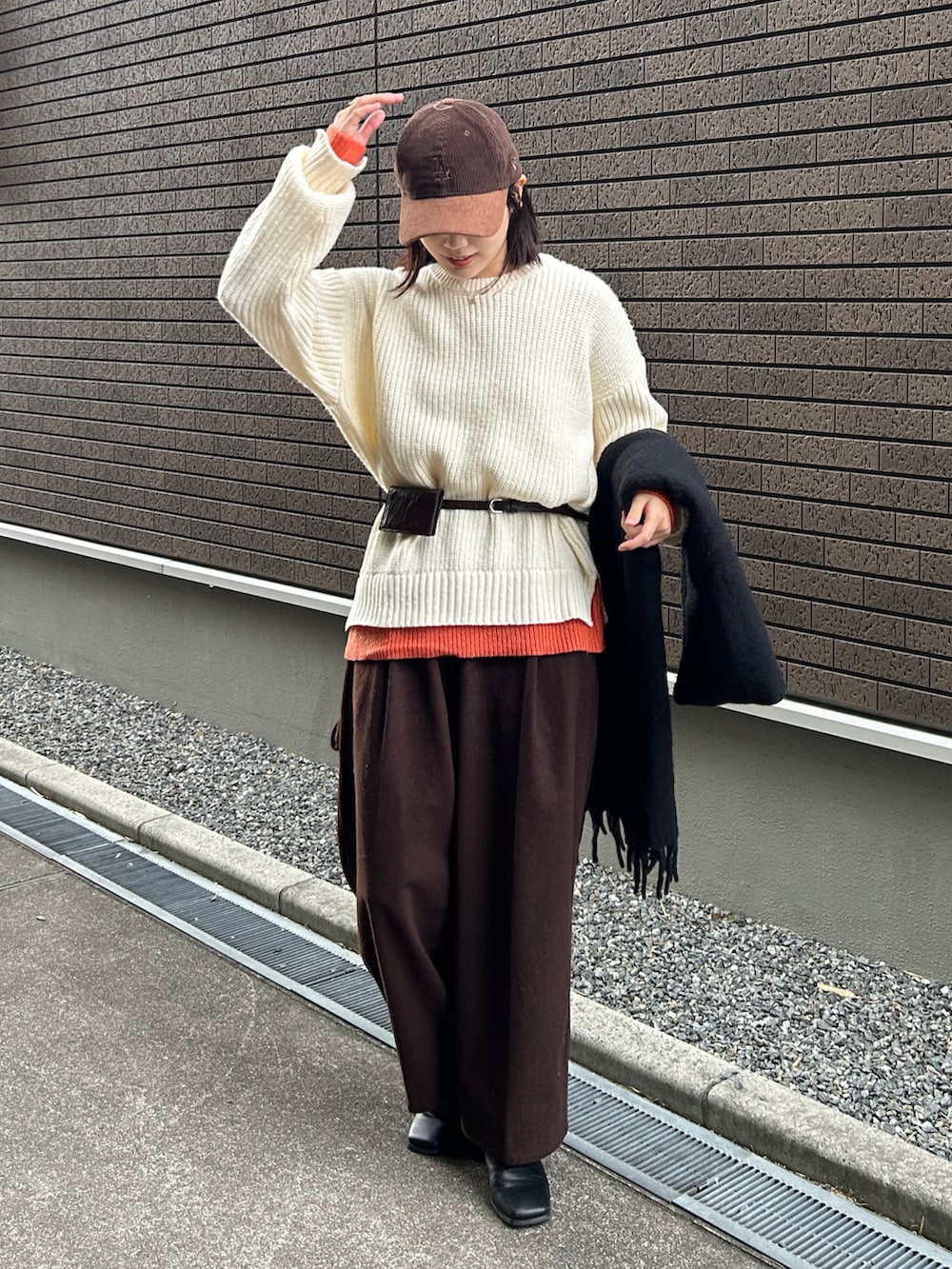 ホワイト系のニット/セーター、ブラック系のブーツ、ブラウン系のその他パンツを着用したレディースの冬コーディネートの2枚目の写真