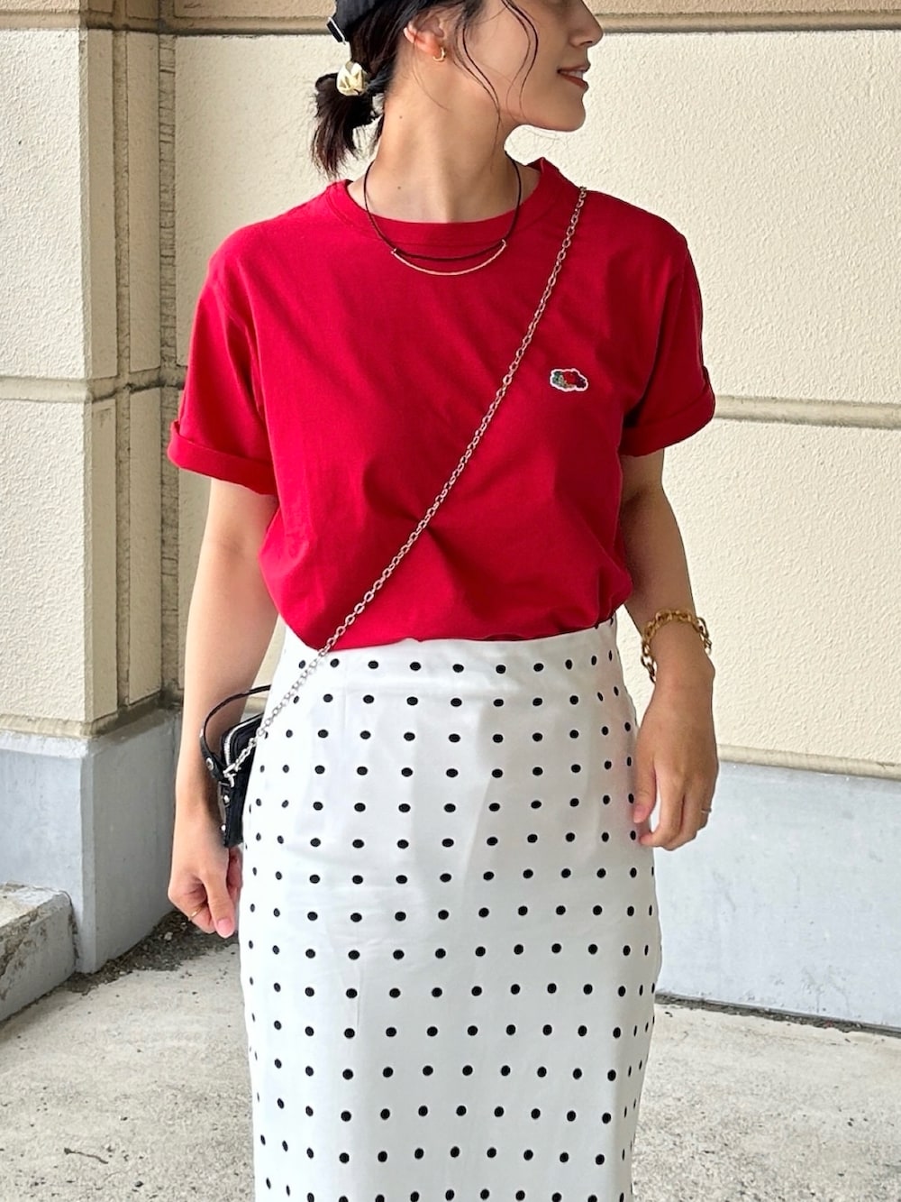 レッド系のTシャツ/カットソー、ホワイト系のスカート、ブラック系のパンプスを着用したレディースの春コーディネートの4枚目の写真