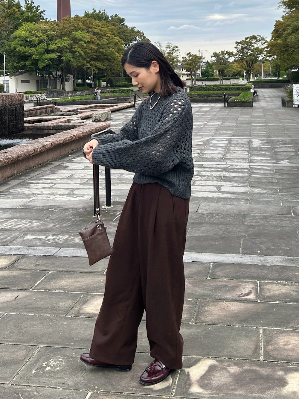 グレー系のニット/セーター、ブラウン系のショルダーバッグ、レッド系のローファーを着用したレディースの秋コーディネートの4枚目の写真