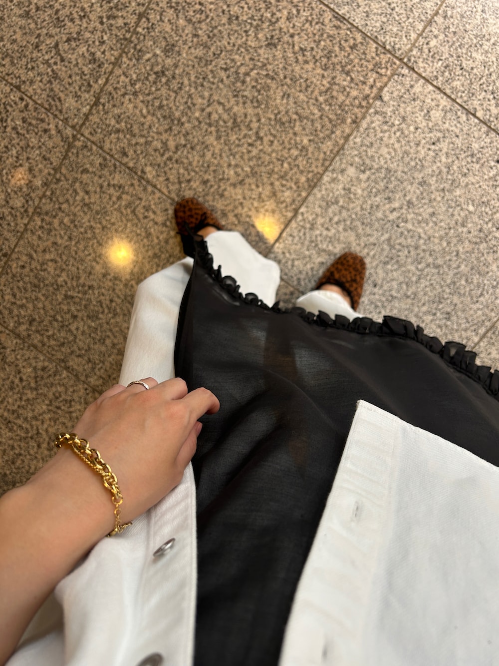 ブラック系のハンドバッグ、ホワイト系のデニムジャケット、ホワイト系のデニムパンツを着用したレディースの秋コーディネートの4枚目の写真