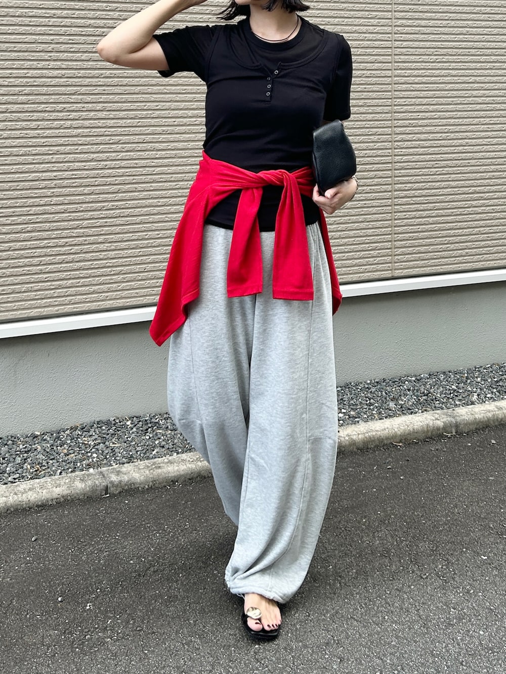 グレー系のスウェットパンツ、ブラック系のサンダル、ブラック系のハンドバッグを着用したレディースの夏コーディネートの4枚目の写真