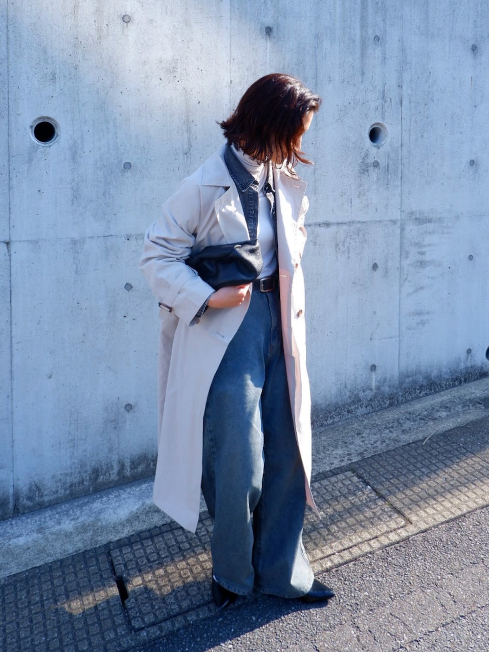 ホワイト系のトレンチコート、ブルー系のデニムパンツ、ブラック系のパンプスを着用したレディースの春コーディネートの3枚目の写真