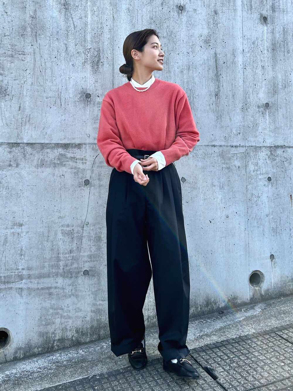 ブラック系のパンツ、ピンク系のニット/セーター、ブラック系のローファーを着用したレディースの春コーディネートの3枚目の写真
