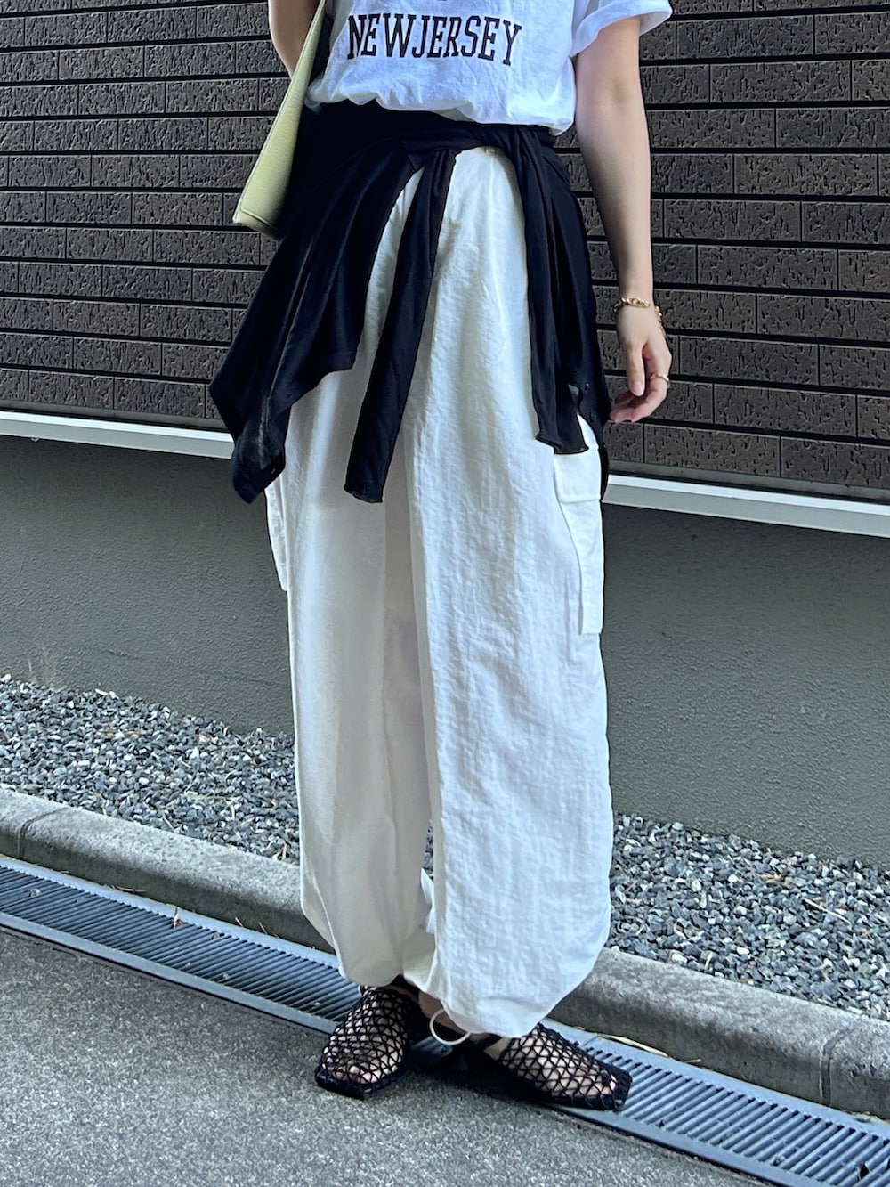 ホワイト系のTシャツ/カットソー、ホワイト系のカーゴパンツ、グリーン系のハンドバッグを着用したレディースの夏コーディネートの3枚目の写真