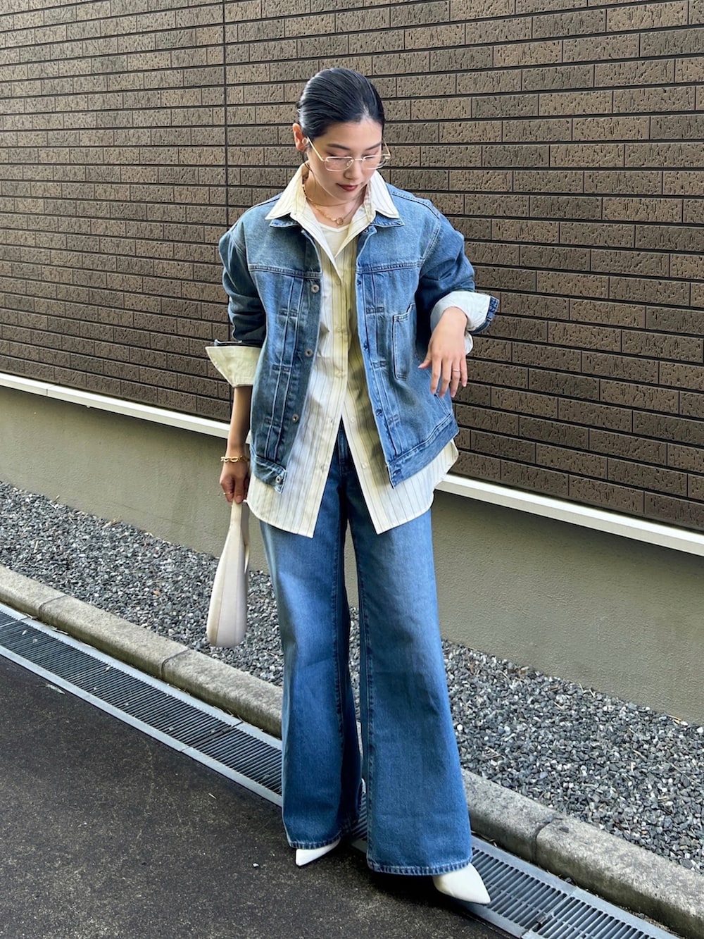 イエロー系のシャツ/ブラウス、ホワイト系のショルダーバッグ、ホワイト系のパンプスを着用したレディースの冬コーディネートの4枚目の写真