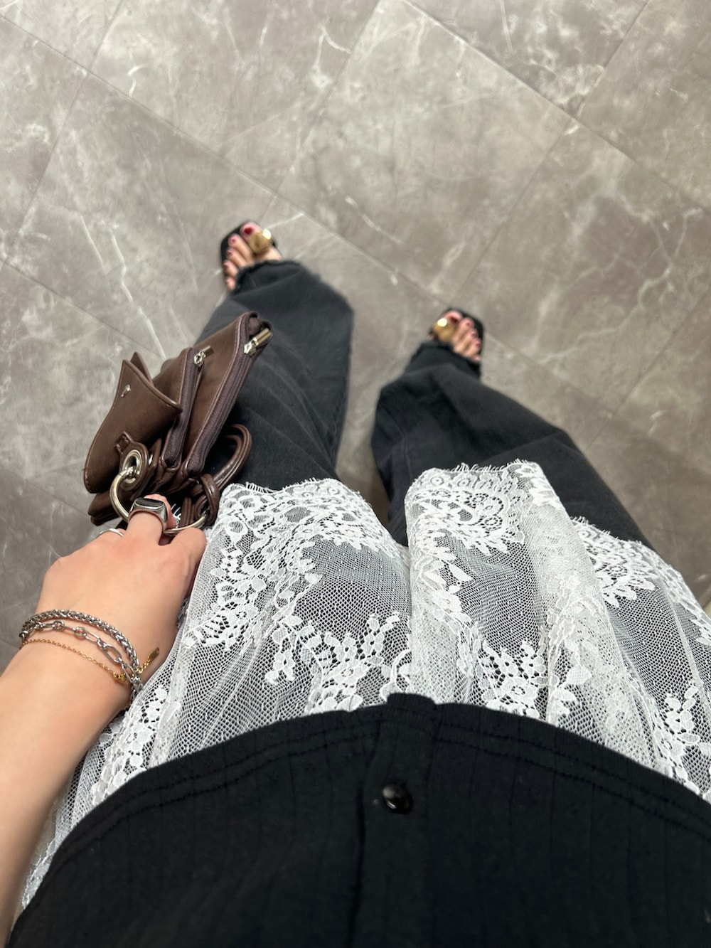 その他のデニムパンツ、ブラック系のサンダル、ブラウン系のショルダーバッグを着用したレディースの夏コーディネートの3枚目の写真