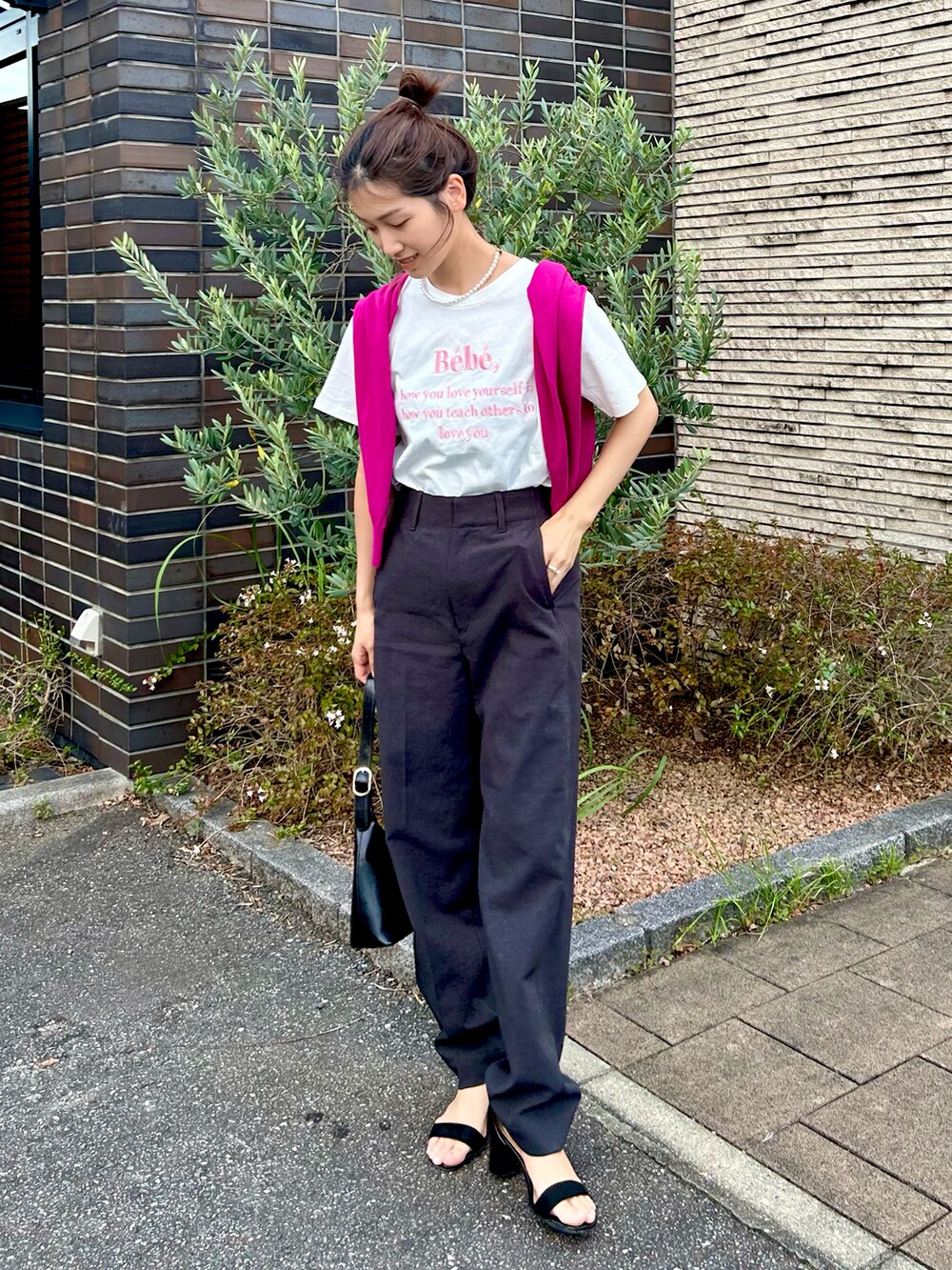 ホワイト系のTシャツ/カットソー、グレー系のパンツ、ブラック系のハンドバッグを着用したレディースの秋コーディネートの4枚目の写真