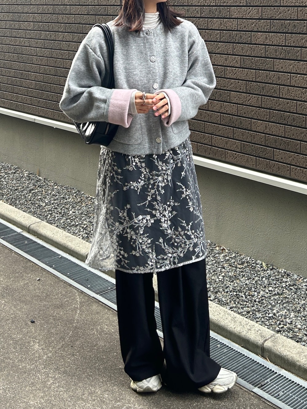 グレー系のカーディガン/ボレロ、シルバー系のワンピース、ブラック系のスラックスを着用したレディースの冬コーディネートの4枚目の写真