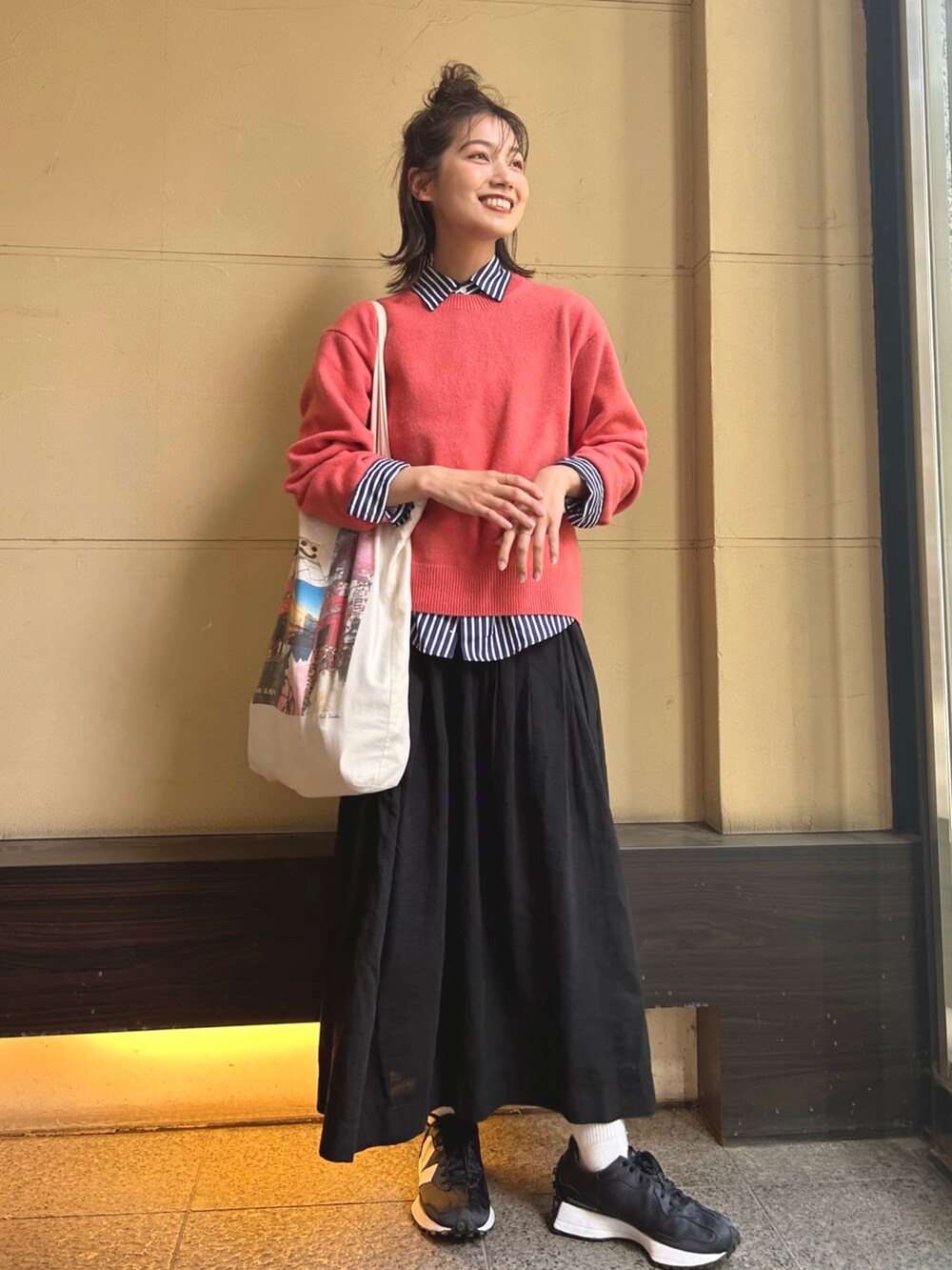 ピンク系のニット/セーター、ブルー系のシャツ/ブラウス、ホワイト系のトートバッグを着用したレディースの春コーディネートの3枚目の写真