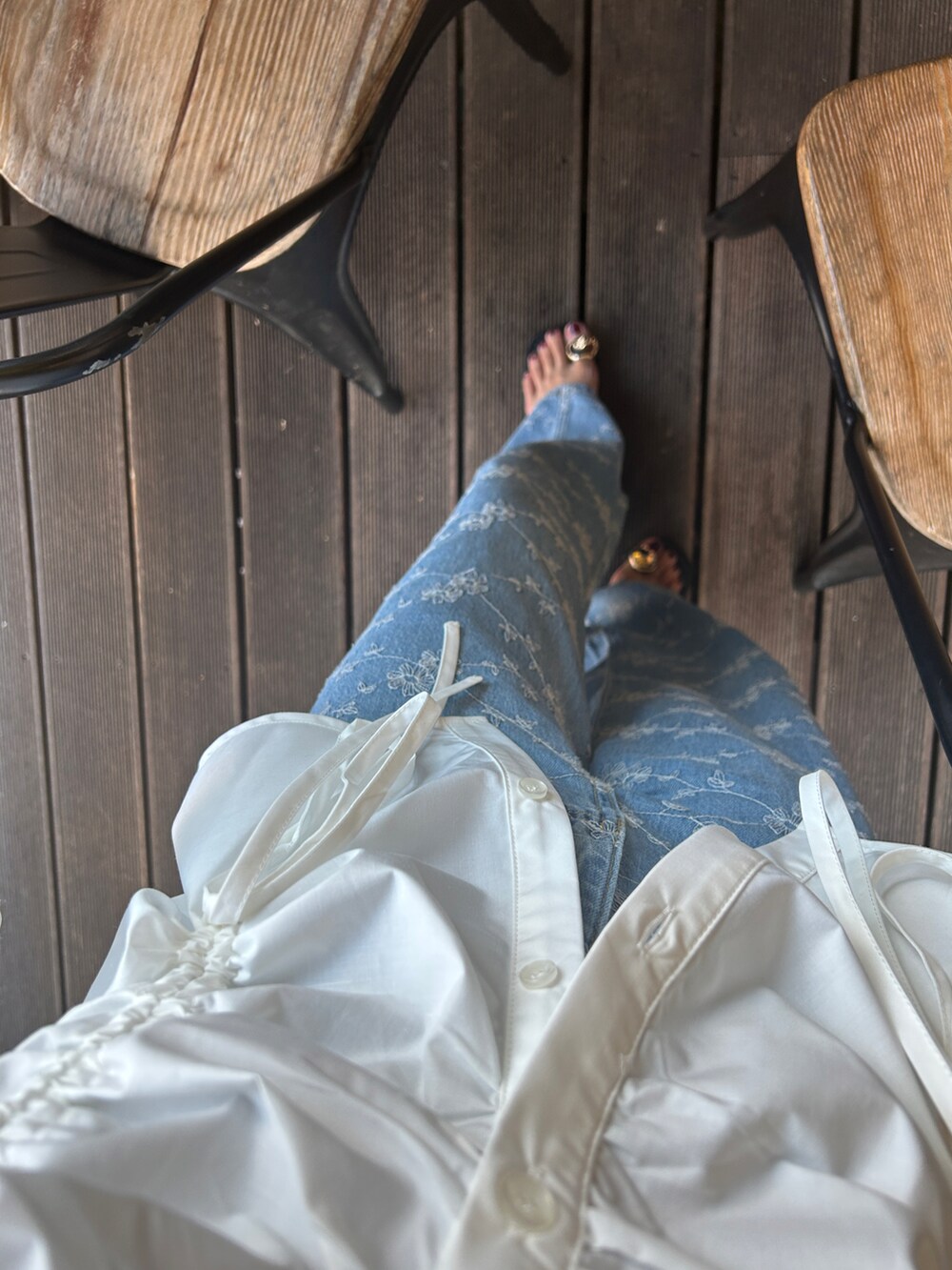 ブラック系のサンダル、ホワイト系のシャツ/ブラウス、ブルー系のデニムパンツを着用したレディースの夏コーディネートの3枚目の写真