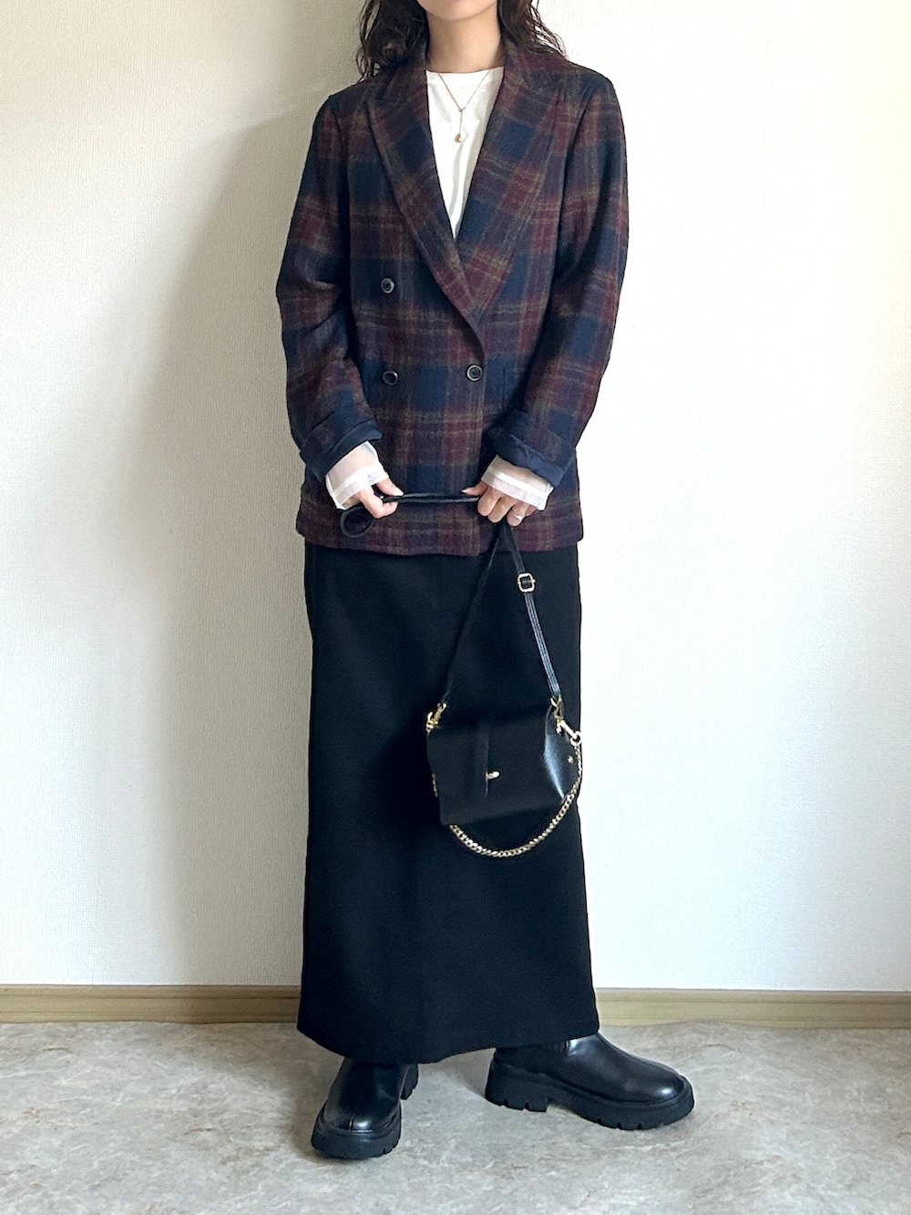 ブルー系のテーラードジャケット、ホワイト系のTシャツ/カットソー、ブラック系のスカートを着用したレディースの秋コーディネートの2枚目の写真