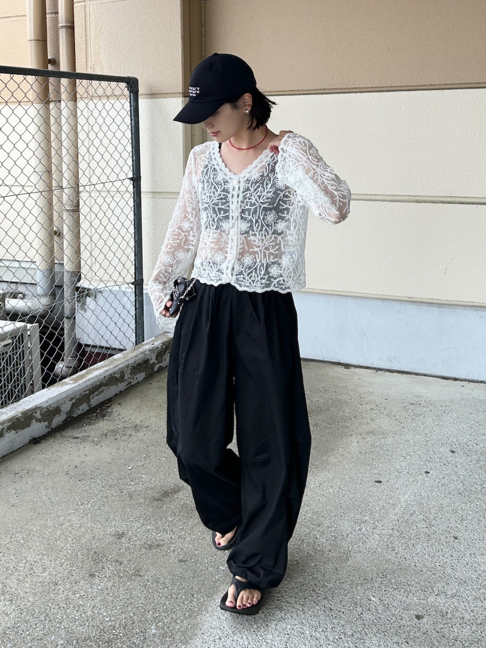 ブラック系のその他パンツ、ホワイト系のカーディガン/ボレロ、ブラック系のサンダルを着用したレディースの夏コーディネートの4枚目の写真
