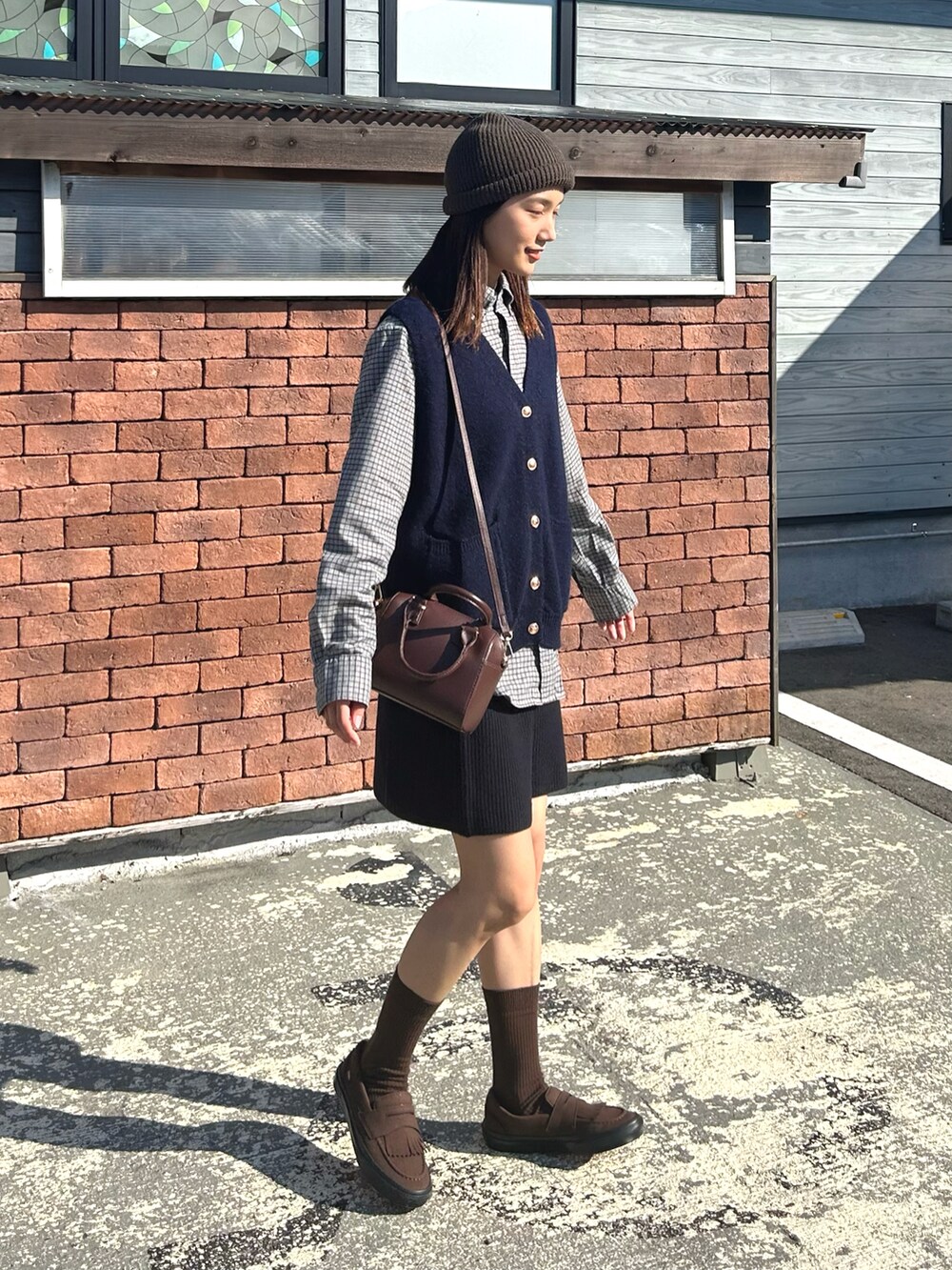 ブルー系のベスト、グレー系のシャツ/ブラウス、ブラウン系のボストンバッグを着用したレディースの秋コーディネートの4枚目の写真