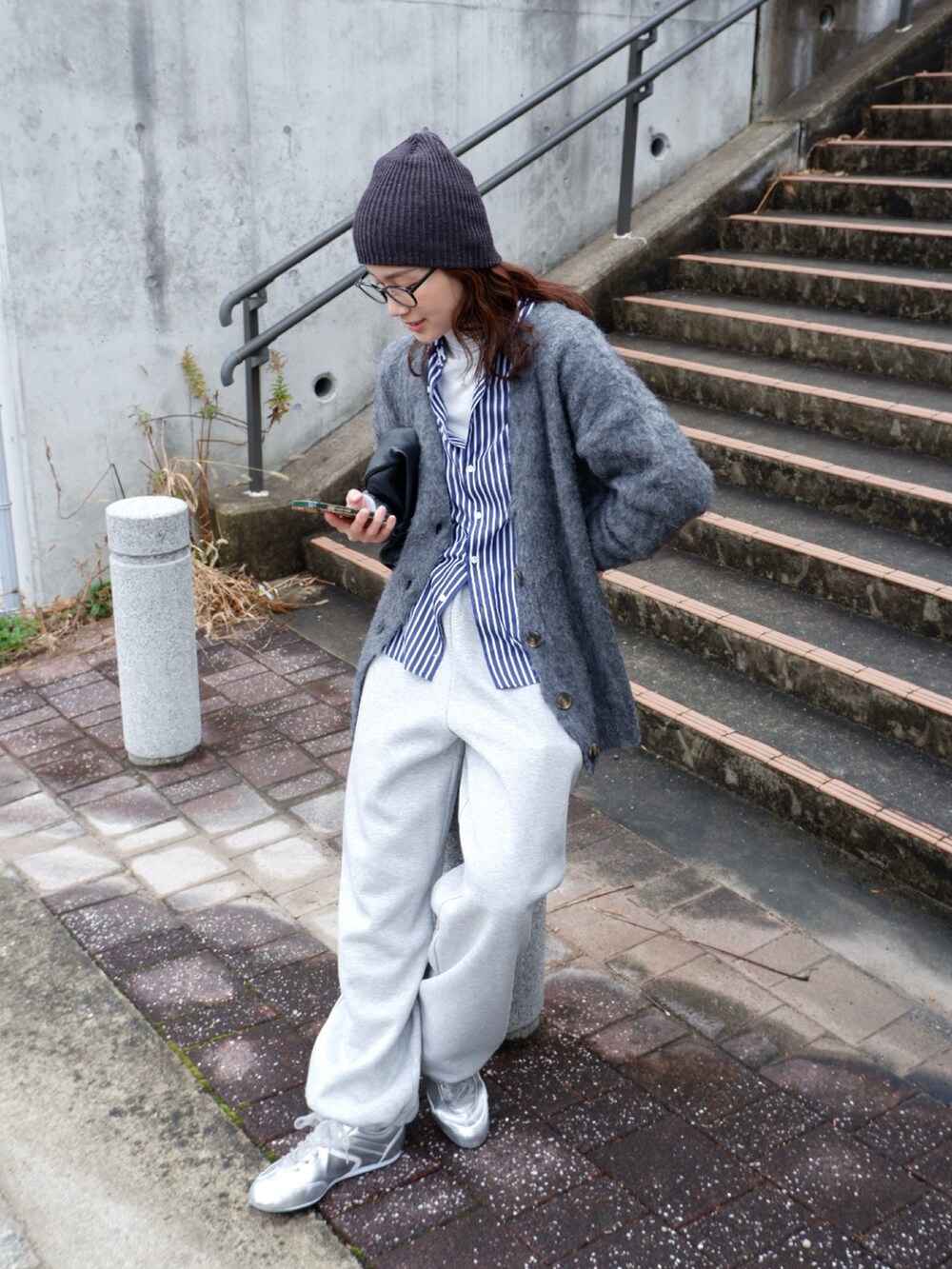 ブルー系のシャツ/ブラウス、グレー系のカーディガン/ボレロ、ブラック系のハンドバッグを着用したレディースの冬コーディネートの2枚目の写真