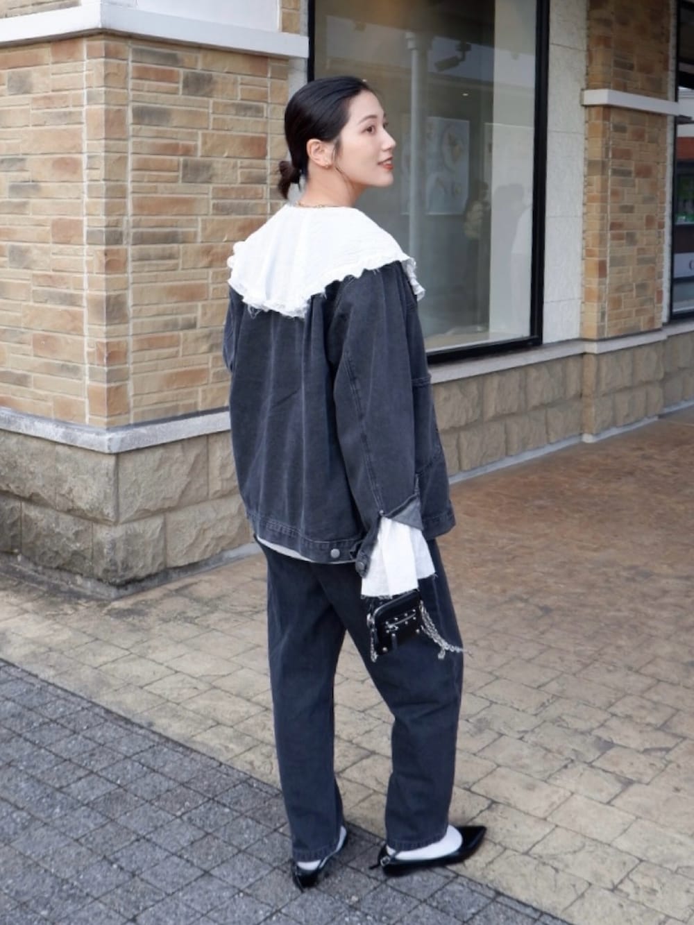 ホワイト系のシャツ/ブラウス、ブラック系のデニムジャケット、ブラック系のデニムパンツを着用したレディースの冬コーディネートの2枚目の写真