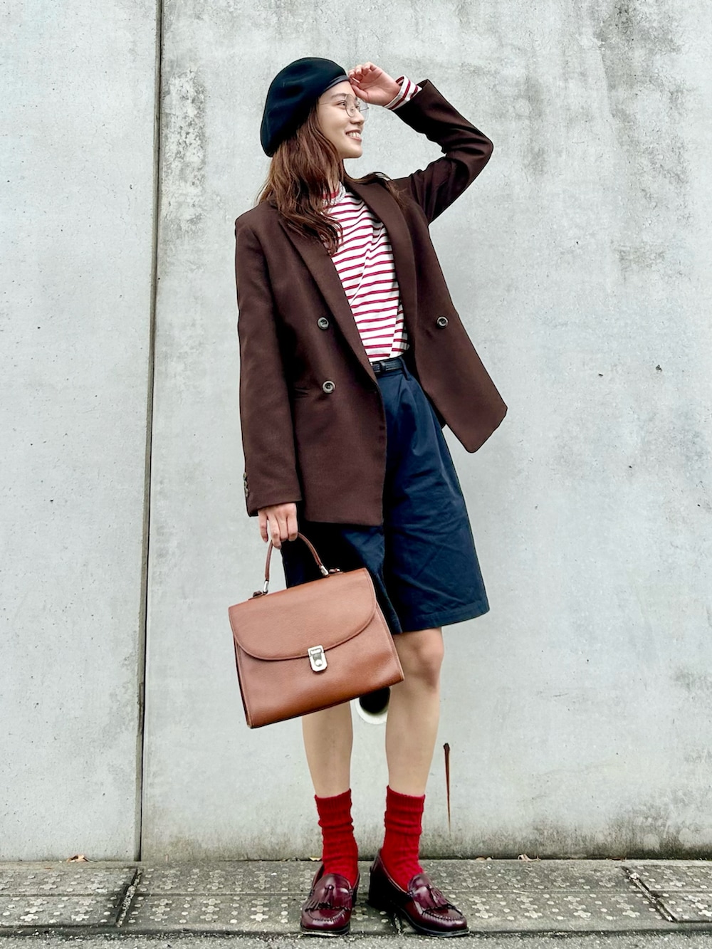 レッド系のTシャツ/カットソー、ブラック系のチノパンツ、ブラウン系のバッグを着用したレディースの春コーディネートの2枚目の写真
