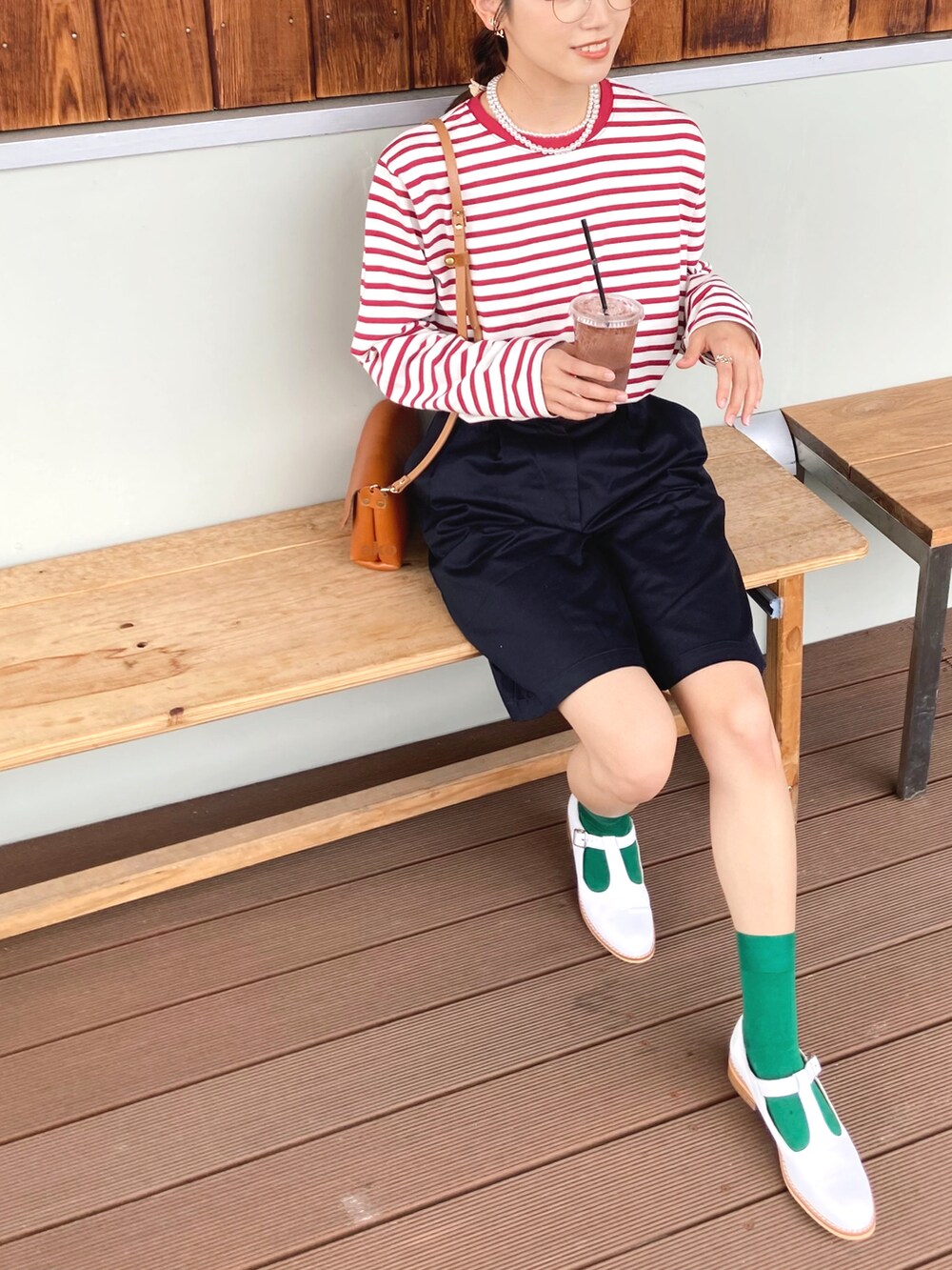 ホワイト系のローファー、ブラック系のチノパンツ、レッド系のTシャツ/カットソーを着用したレディースの夏コーディネートの2枚目の写真