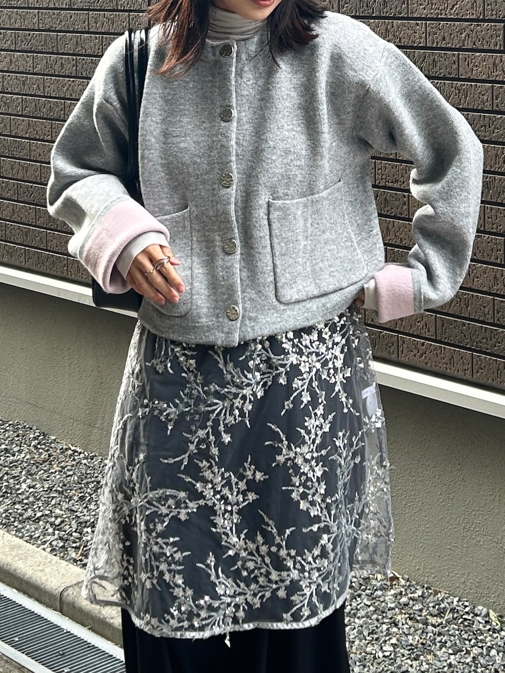 グレー系のカーディガン/ボレロ、シルバー系のワンピース、ブラック系のスラックスを着用したレディースの冬コーディネートの2枚目の写真