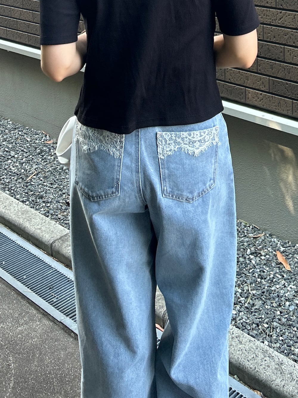 ブラック系のTシャツ/カットソー、ブルー系のデニムパンツ、ブラック系のサンダルを着用したレディースの夏コーディネートの2枚目の写真
