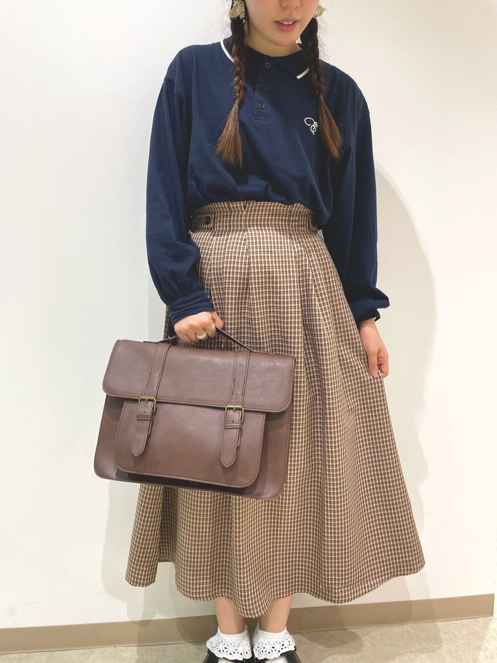 ブルー系のTシャツ/カットソー、ブラウン系のスカート、ブラウン系のハンドバッグを着用したレディースの夏コーディネートの3枚目の写真