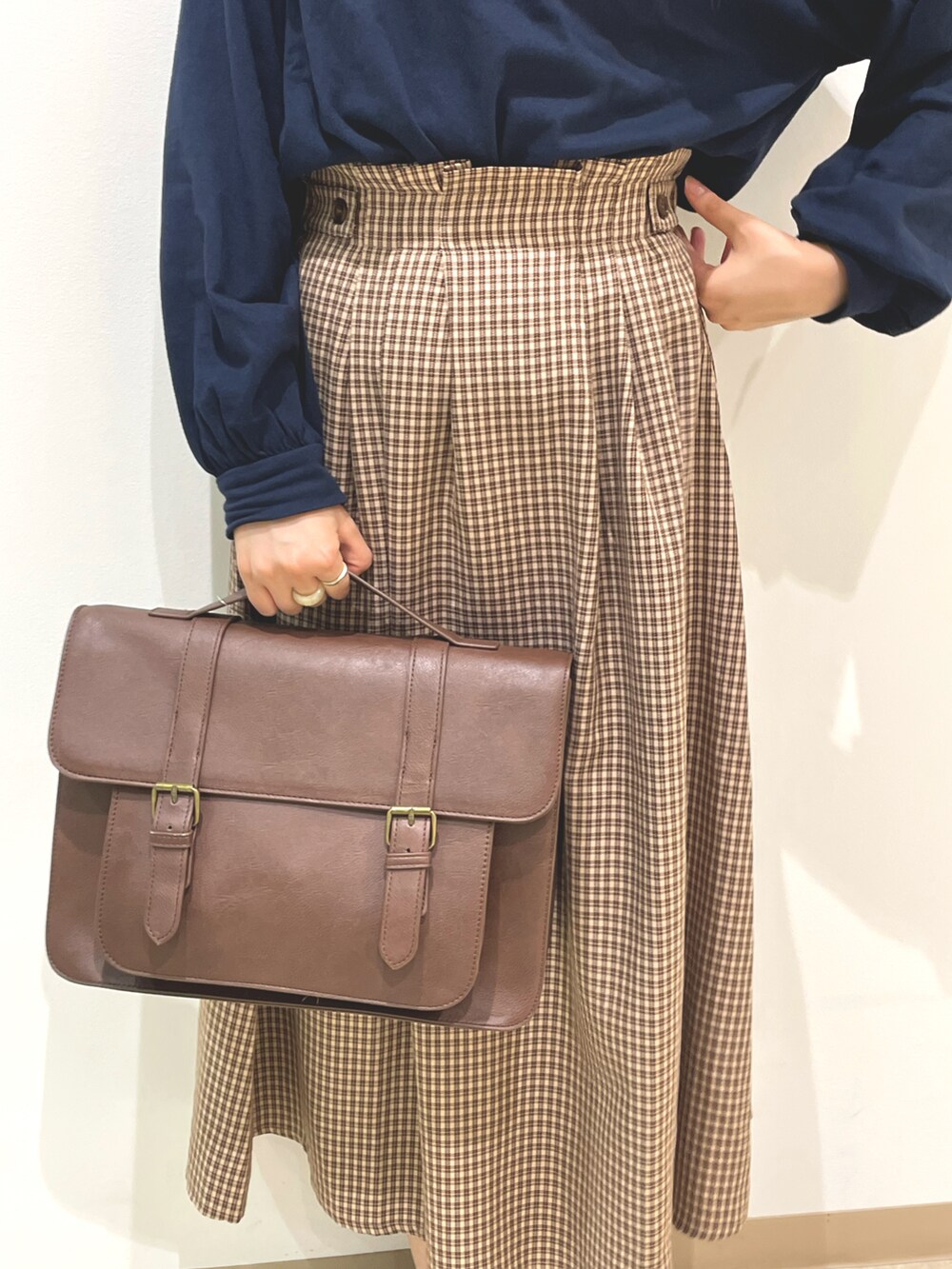 ブルー系のTシャツ/カットソー、ブラウン系のスカート、ブラウン系のハンドバッグを着用したレディースの夏コーディネートの4枚目の写真