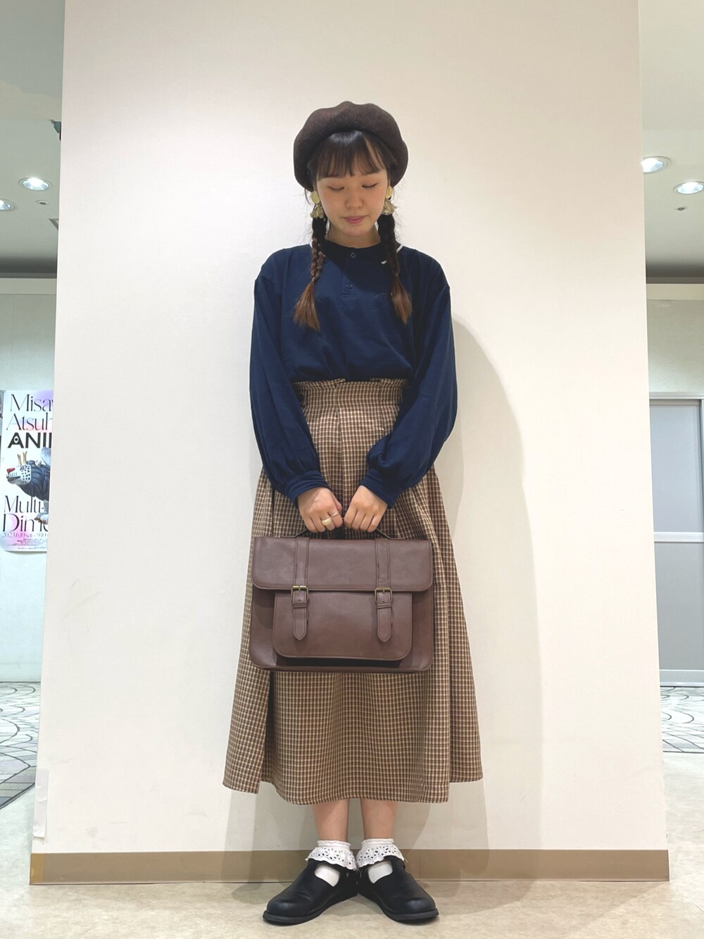 ブルー系のTシャツ/カットソー、ブラウン系のスカート、ブラウン系のハンドバッグを着用したレディースの夏コーディネートの2枚目の写真