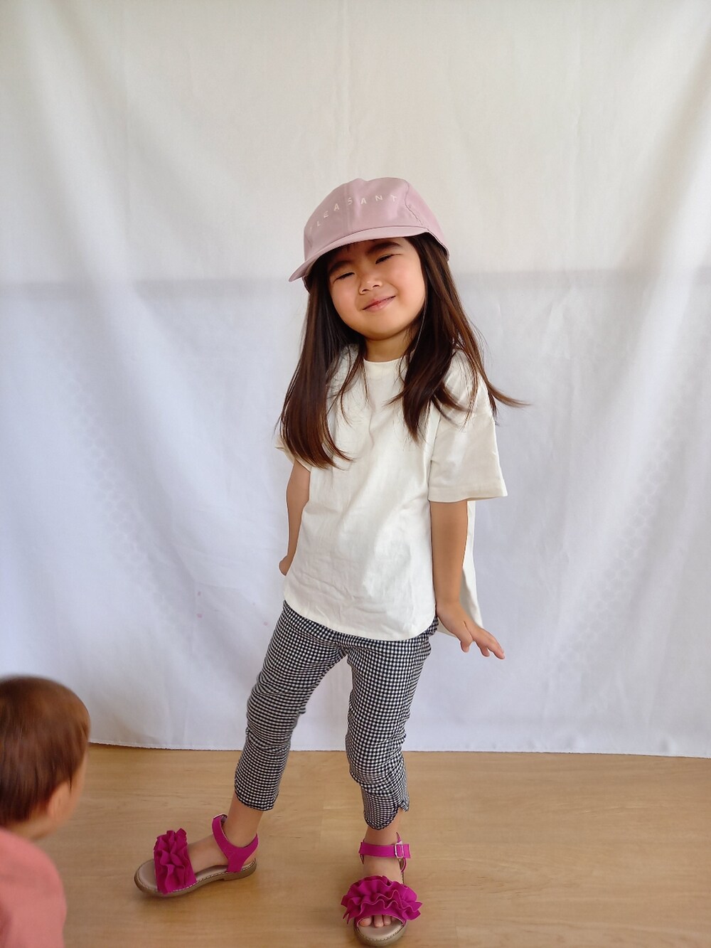 ピンク系のサンダル、ホワイト系のTシャツ/カットソー、ブラック系のその他パンツを着用したキッズの夏コーディネートの2枚目の写真