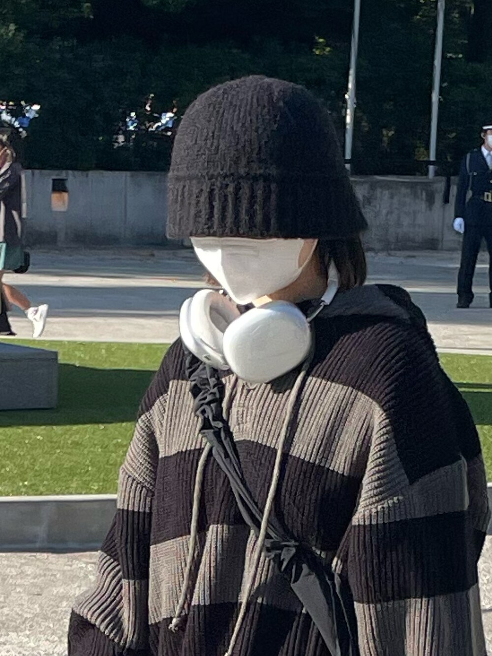 グレー系のニット/セーター、ブラック系のスニーカー、ブラック系のニットキャップ/ビーニーを着用したレディースの秋コーディネートの2枚目の写真