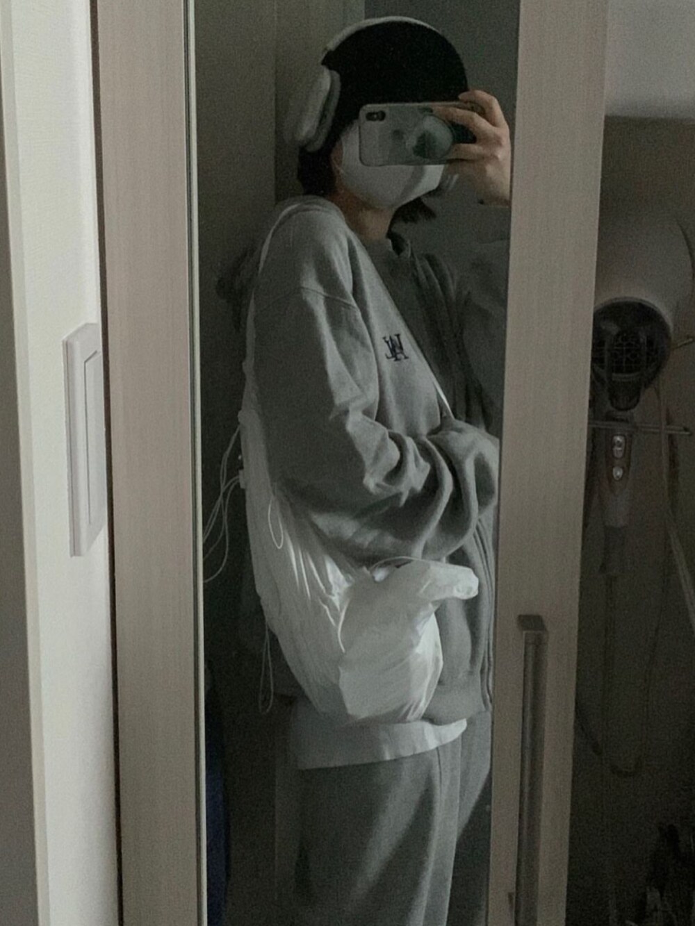 グレー系のバッグ、ホワイト系のバッグ、グレー系のトップスを着用したレディースの冬コーディネートの2枚目の写真