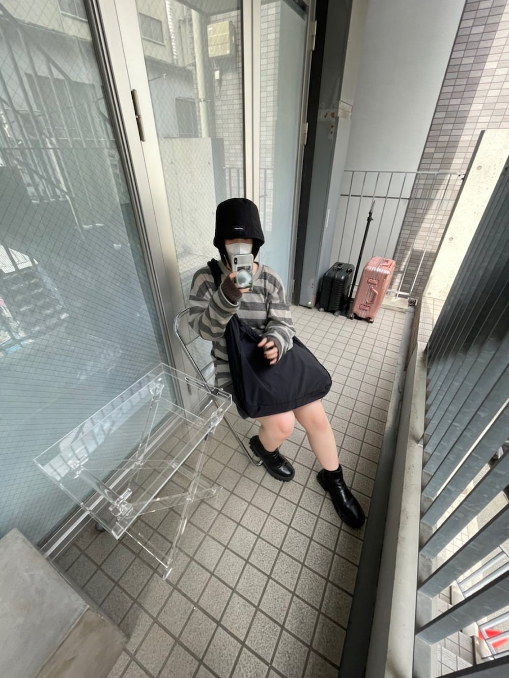 ベージュ系のトップス、ブラック系のハットを着用したレディースの夏コーディネートの3枚目の写真