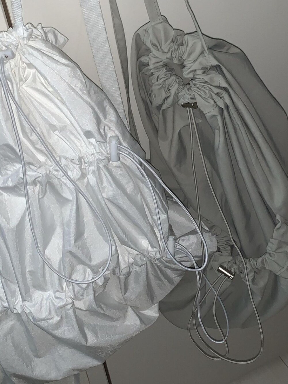 グレー系のバッグ、ホワイト系のバッグ、グレー系のトップスを着用したレディースの冬コーディネートの4枚目の写真