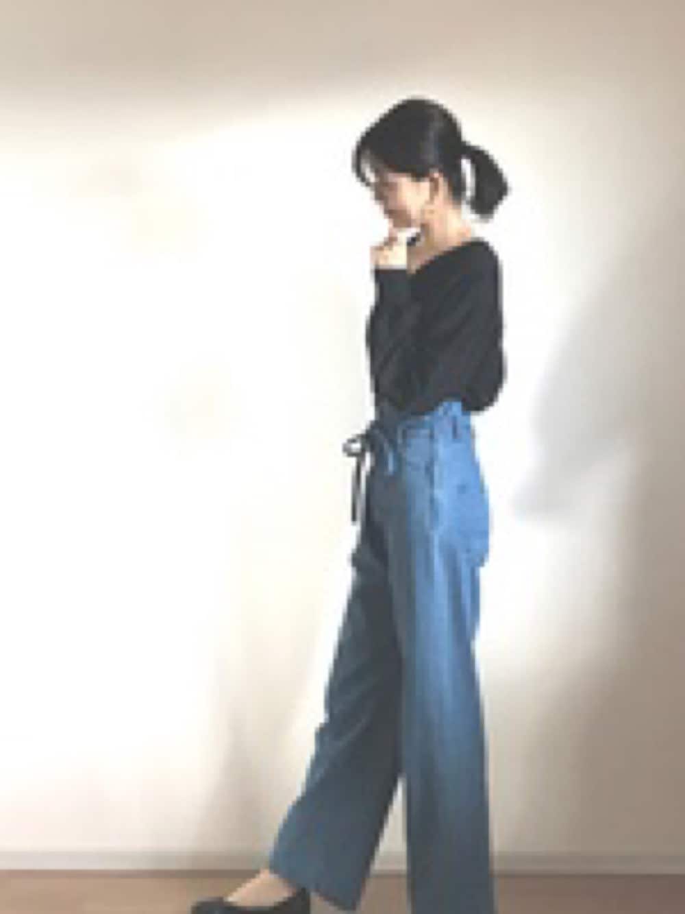 ブルー系のデニムパンツ、ブラック系のシャツ/ブラウスを着用したレディースの秋コーディネートの2枚目の写真