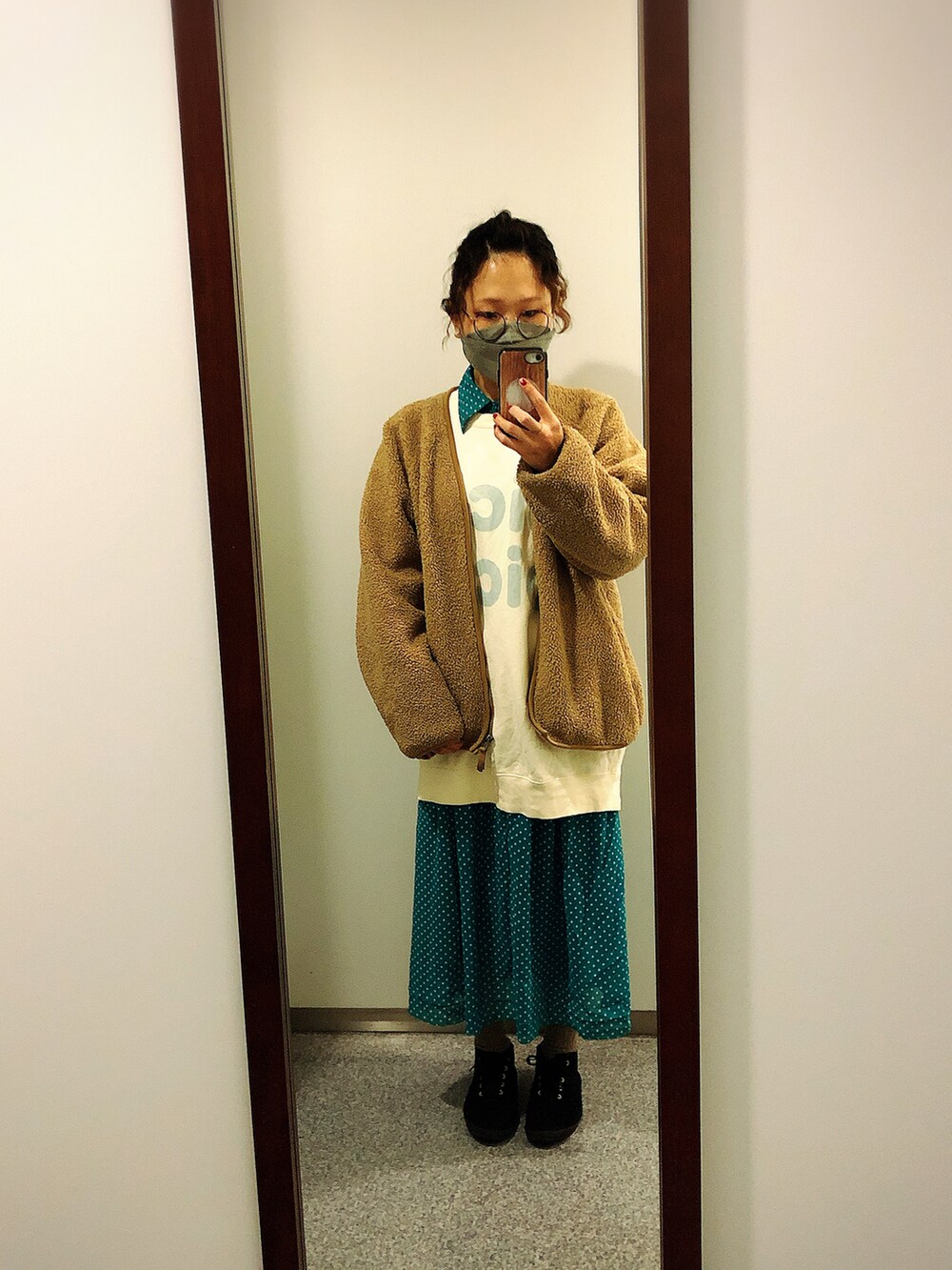 グリーン系のワンピース、イエロー系のスウェット、ブラック系のスニーカーを着用したレディースの冬コーディネートの2枚目の写真