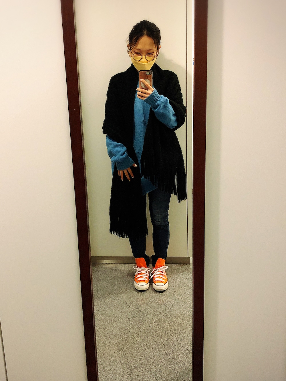 ブルー系のデニムパンツ、ブルー系のニット/セーター、オレンジ系のスニーカーを着用したレディースの冬コーディネートの2枚目の写真