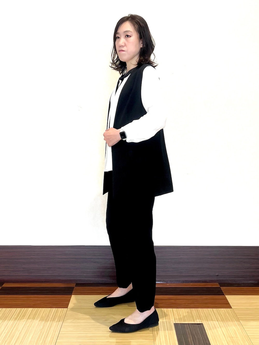 ホワイト系のシャツ/ブラウス、ブラック系のベスト、ブラック系のスーツパンツを着用したレディースの春コーディネートの4枚目の写真