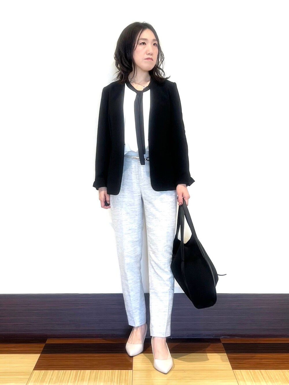 ブラック系のスーツジャケット、ホワイト系のシャツ/ブラウス、ブラック系のその他パンツを着用したレディースの春コーディネートの2枚目の写真
