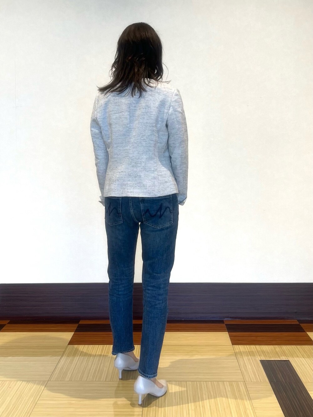 ブラック系のノーカラージャケット、ホワイト系のシャツ/ブラウス、ブルー系のデニムパンツを着用したレディースの春コーディネートの5枚目の写真