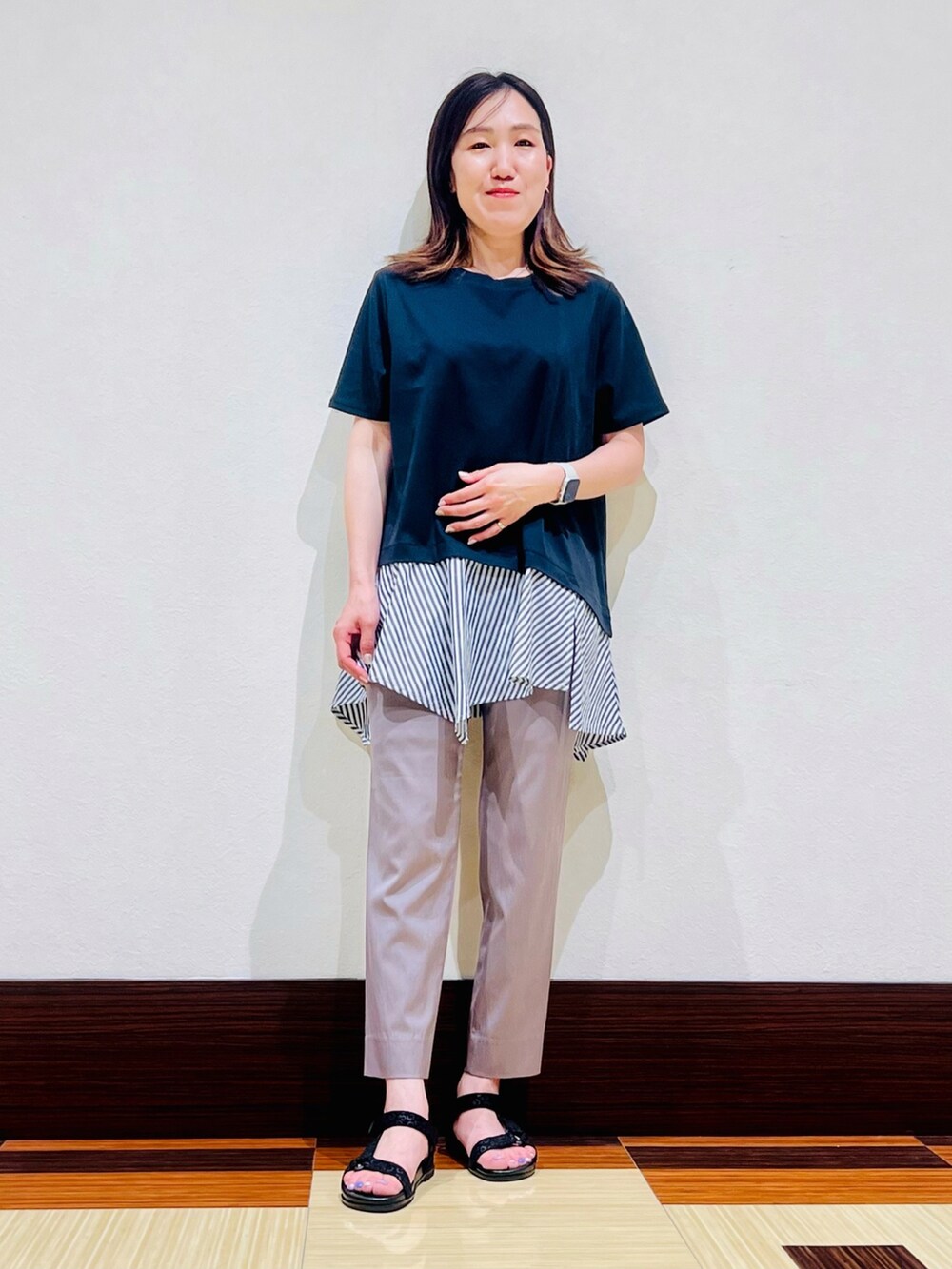 ブルー系のTシャツ/カットソー、ブラック系のサンダル、ブラウン系のその他パンツを着用したレディースの夏コーディネートの2枚目の写真