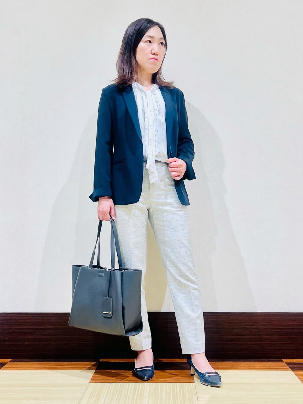 ブルー系のスーツジャケット、グレー系のシャツ/ブラウス、ブラック系のスーツパンツを着用したレディースの春コーディネートの3枚目の写真